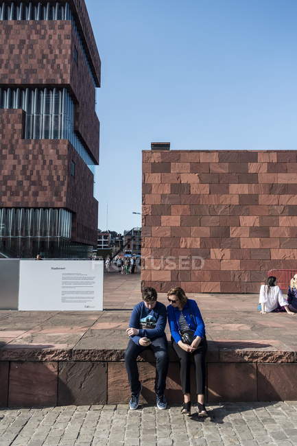 6 августа 2016 года. Бельгия, Антверпен, музей Мас. Люди сидят на камнях — стоковое фото