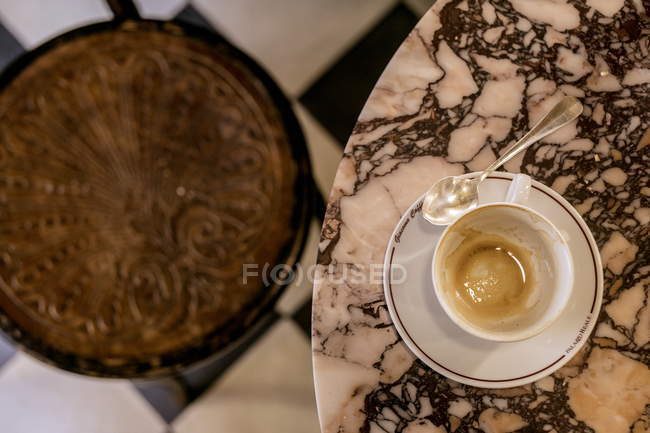 Vista dall'alto di caffè rimane in tazza sul tavolo di marmo e sedia scolpita sfocata — Foto stock