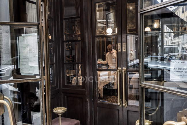 23 de febrero de 2017. Milan, Giacomo Bistrot. Hombre usando el teléfono en el restaurante - foto de stock
