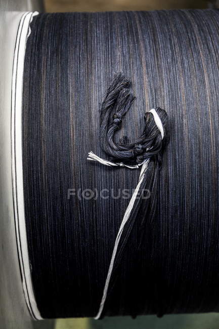Vue rapprochée de fils de laine foncée attachés ensemble sur bobine — Photo de stock