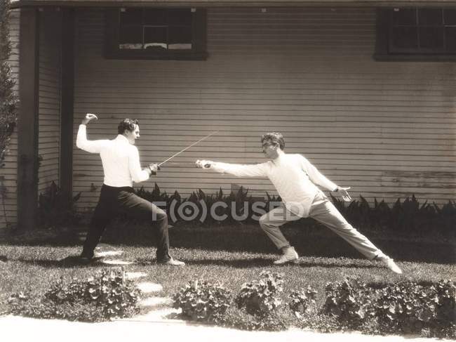 Homens lutando com espadas de esgrima — Fotografia de Stock