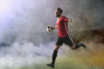 Il calciatore festeggia il gol, correndo attraverso il campo di calcio nel fumo — Foto stock