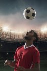 Football player hits the ball of head — Stock Photo