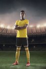 Giocatore di calcio ritratto in piedi con lo stadio sullo sfondo — Foto stock
