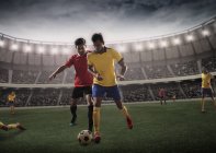Соперничающие футболисты в борьбе за владение футболом — стоковое фото