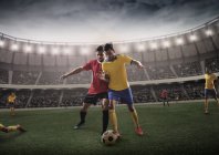 Joueurs de football rivaux dans la lutte pour la possession de football — Photo de stock