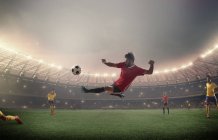 Fußballer kickt vor Flutlicht — Stockfoto