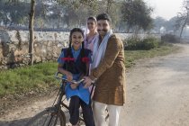 Heureuse famille rurale avec vélo dans la rue du village — Photo de stock