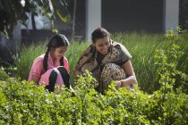 Индийская мать с дочерью на зеленом поле фермы в солнечный день — стоковое фото
