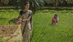Madre india con hija en campo de granja verde en día soleado - foto de stock