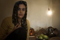 Індійська жінка, що сидить на підлозі кухні — стокове фото