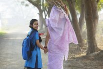 Индийская женщина ходит с дочерью по проселочной дороге — стоковое фото