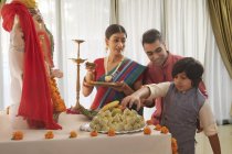 Familia en ropa festiva realizando aarti en Ganesh chaturthi - foto de stock