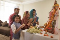 Индийская семья в праздничной одежде празднует ганеш чатурти в помещении — стоковое фото