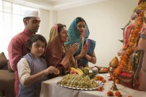 Індійська сім'ї в святковий одяг святкування Ганеш chaturthi в приміщенні — стокове фото