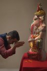 Mulher rezando com as mãos unidas e os olhos fechados na frente de Ganpati Idol — Fotografia de Stock