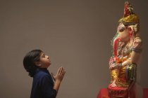 Жінці молитися з рук приєднався і очі закриті перед Ganpati ідол — стокове фото