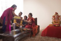 Woman serving prasad to everybody in family — Stock Photo