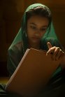 Retrato de menina indiana olhando para almofada de exame sob luz traseira — Fotografia de Stock