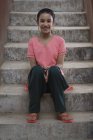 Портрет индийской девушки, сидящей на ступеньках — стоковое фото