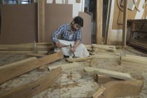 Carpinteiro trabalhando com cinzel e martelo no chão na oficina — Fotografia de Stock