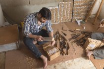 Tischler fertigt Schnitzereien und Entwürfe auf Holz mit Meißel in der Werkstatt — Stockfoto