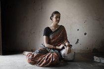 Femme indienne assise sur le sol dans une pièce faiblement éclairée — Photo de stock