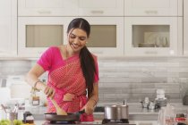 Женщина в сари приготовления пищи на кухне — стоковое фото