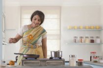 Woman holding sweet dish in kitchen — Stock Photo