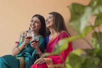 Mulheres em saree tomando uma bebida juntos — Fotografia de Stock