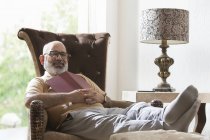 Старший чоловік розслабляється в своєму будинку — стокове фото