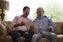 Son showing something to his father on the tablet — Stock Photo