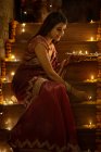 Junge Frau schmückt Treppen mit Diyas auf Diwali — Stockfoto