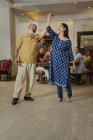 Бабушка и дедушка танцуют в гостиной перед семьей . — стоковое фото
