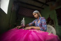 Молодая девушка сшивает с швейной машинкой — стоковое фото