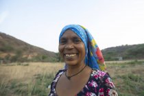 Mulher de pé em uma fazenda e sorrindo — Fotografia de Stock
