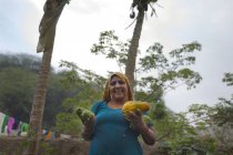 Mujer sosteniendo frutas y sonriendo - foto de stock