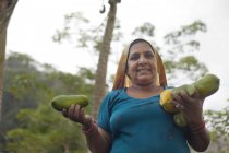 Жінка тримає фрукти і посміхається — стокове фото