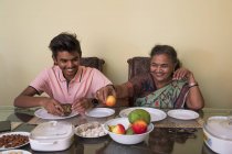 Grand-mère servant son petit-fils sur la table à manger à la maison . — Photo de stock