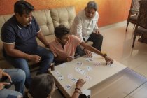 Glückliche Familie beim Kartenspielen im heimischen Wohnzimmer. — Stockfoto