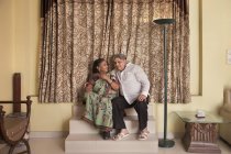 Senior couple sitting on the stairs at home. — Stock Photo