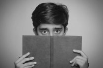 Ritratto in bianco e nero di un ragazzo che tiene in mano un libro. bianco e nero — Foto stock