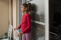 Young girl standing in the balcony at home. — Stock Photo