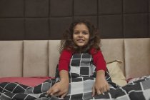 Young girl enjoying the comfort of a blanket at home. — Stock Photo