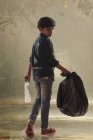 Niño recogiendo basura de las calles y ayudando al medio ambiente . - foto de stock