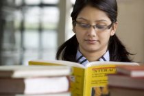 Mädchen liest ein Buch in einer Schulbibliothek — Stockfoto
