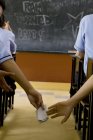 Estudantes trocando um pedaço de papel em uma sala de aula — Fotografia de Stock