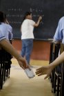 Schüler tauschen einen Zettel im Klassenzimmer aus — Stockfoto
