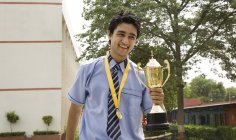 Студент тримає трофей на шкільному подвір'ї — стокове фото
