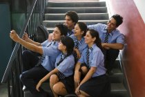 Estudiantes tomando un autorretrato en las escaleras de la escuela - foto de stock